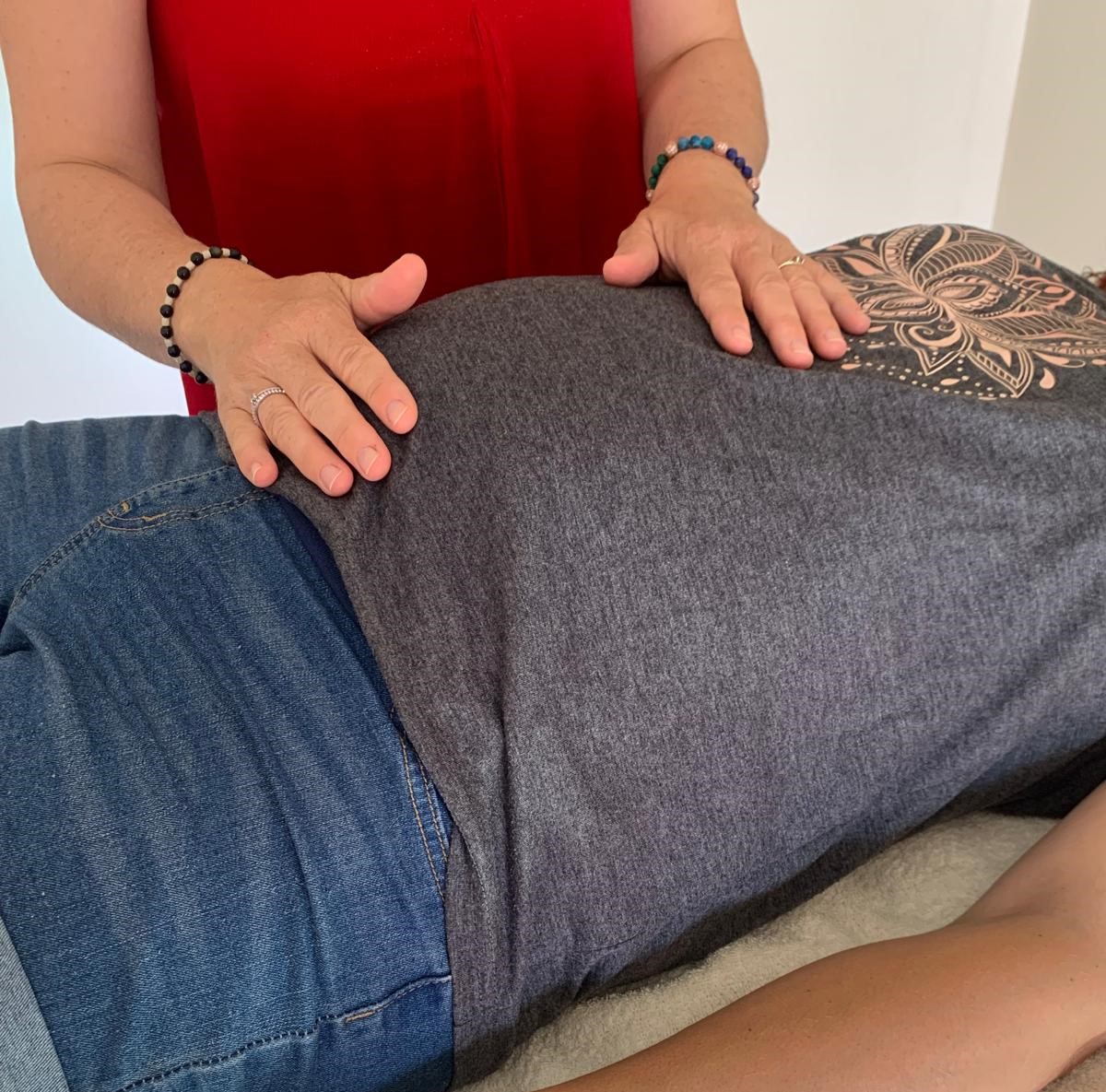 main qui masse une femme enceinte